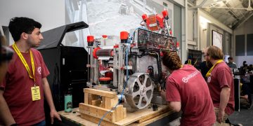 students inspect lunar mining robot