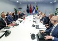 NATO officials sit around a table