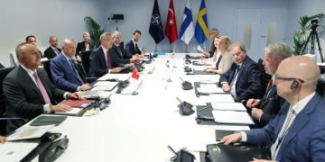 NATO officials sit around a table