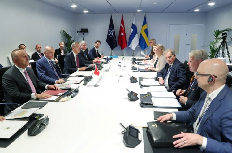 NATO officials sit around a table