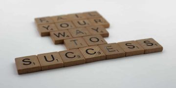 Woman writing on a whiteboard with a dry eras marker next to sticky notes