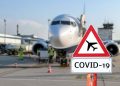 Airplane at the airport with a coronavirus sign in the foreground [Covid-19, travel, planes]