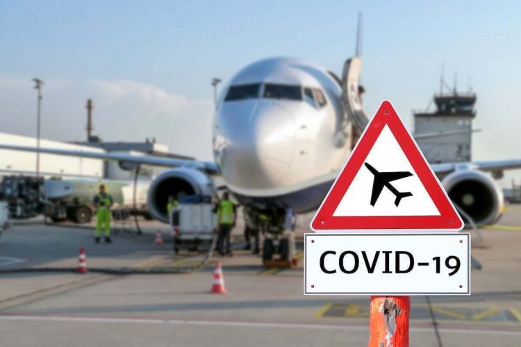 Airplane at the airport with a coronavirus sign in the foreground [Covid-19, travel, planes]