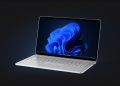A silver Windows 11 laptop on a black background.