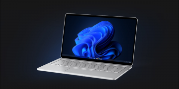 A silver Windows 11 laptop on a black background.