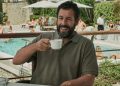 Adam Sandler drinking a coffee and laughing in Netflix's Hustle