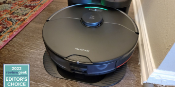 roborock vacuum cleaner in its dock station on a wooden floor