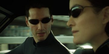 Image of a virtual Neo and Trinity from the Matrix, driving in a car wearing sunglasses.