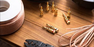Banana plug type speaker connectors and audio wiring on a work table.