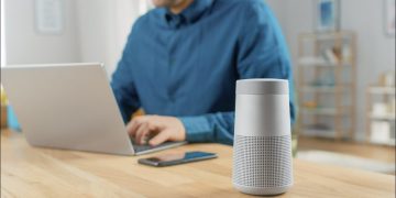 Person using bluetooth speaker with laptop