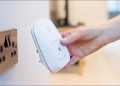 A woman plugging a smart plug into a wall outlet.