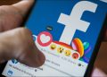Closeup of a person selecting the "Love" reaction to a post on the Facebook mobile app.