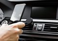 A person docking their phone on a magnetic in-car phone dock.