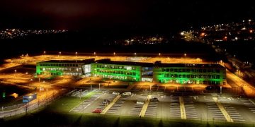 Night shot of the TCS Global Delivery Centre in Letterkenny. Sprawling building with lots of lights amid pitch darkness surrounding it. Lights from other buildings can be seen in the distance.