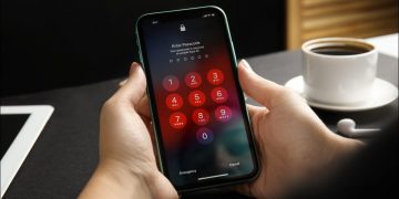 Hands entering the passcode on an iPhone 11 lock screen.