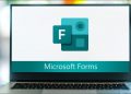 A laptop screen showing the Microsoft Forms logo.