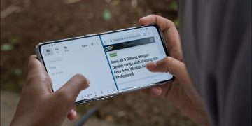 Person's hands holding an Android phone and using it in split-screen mode.