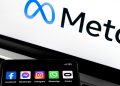 Silhouette of smartphone with Facebook, Messenger, whatsApp, Instagram, Oculus apps and blurred META logo on background.