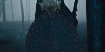 Dane DiLiegro as The Predator with a shield in the forest in Prey