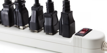 A bunch of cables plugged into a surge protector.