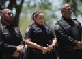A Uvalde police department officer, standing next to Uvalde CISD police chief Pete Arredondo, reacts during a press conference in Uvalde, Texas.