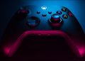 Closeup of a carbon black Xbox Series S controller in blue and red lighting.