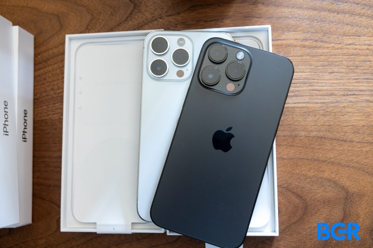 iPhone 14 Pro in Space Black and iPhone 14 Pro in Silver on a wood desk
