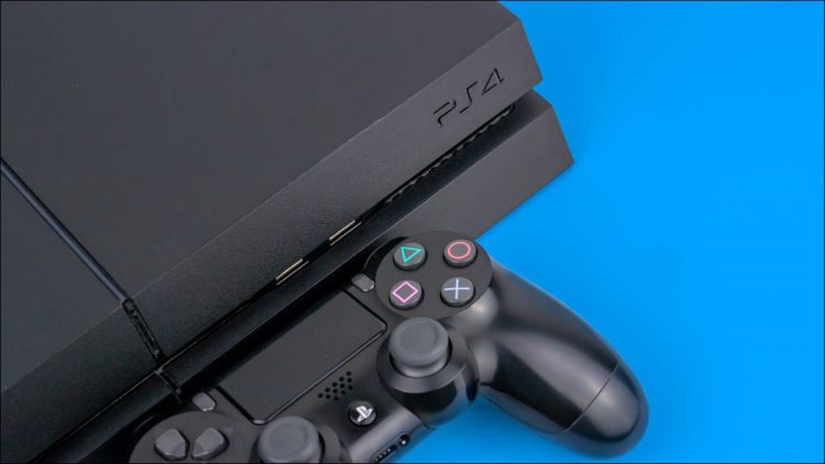 A Sony PS4 console with a DualShock controller next to it on a blue background.