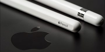 Closeup of an Apple Pencil on an top of an iPad, with the Apple logo visible.