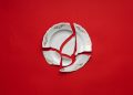 Broken white plate on red background
