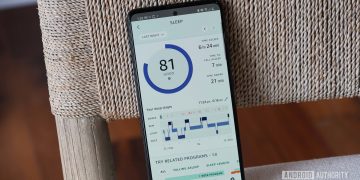 A Samsung Galaxy A51 displays sleep data in the Amazon Halo App on a beige chair.