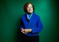 Portrait of Sylvia Earle against a green background