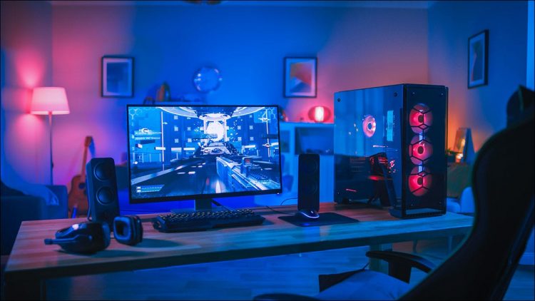 A gaming PC in a room lit by colorful lights.