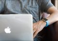 Man using a MacBook while wearing an Apple Watch