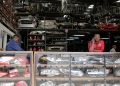 Salesmen wait for customers at a secondhand car parts warehouse, with car parts behind them and on display in the counter, in the industrial area of the capital Nairobi, Kenya