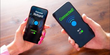 Two smartphones being held next to each other with Wi-Fi hotspot connection confirmations onscreen.