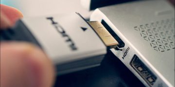 Person holding and connecting an HDMI cable