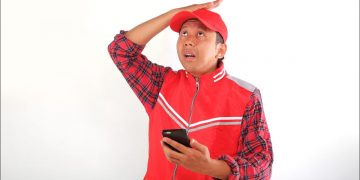 Man with a frustrated expression while using a smartphone.