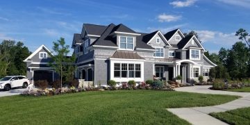 A multi-story home with expansive yard and three-car garage.