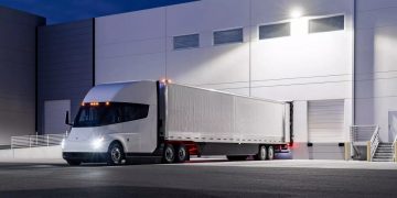 Tesla semi truck parked at a loading dock at night.