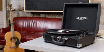 A Victrola record player next to a guitar