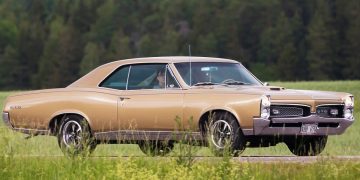 A 1967 Pontiac Tempest GTO drives down a country road.