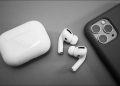 airpods pro on grey table next to iPhone