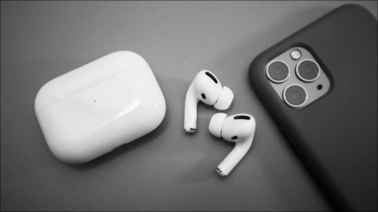 airpods pro on grey table next to iPhone
