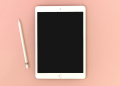 The iPad and Apple Pencil on a pink background.