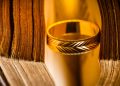 Golden ring between the pages of old book in vintage style, close up, soft focus, The Lord of the Rings, NFT