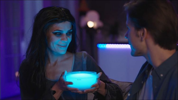 A woman dressed up as a vampire, holding a Govee portable smart light.