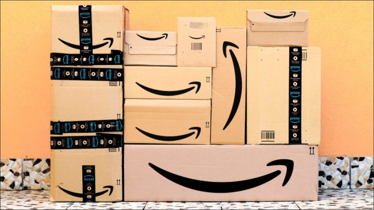 Amazon boxes piled in front of a yellow wall
