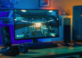 A photo of a gaming monitor next to a PC.
