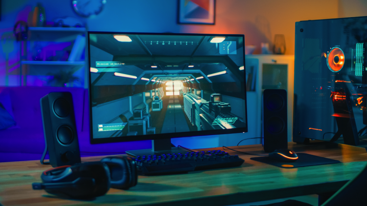 A photo of a gaming monitor next to a PC.